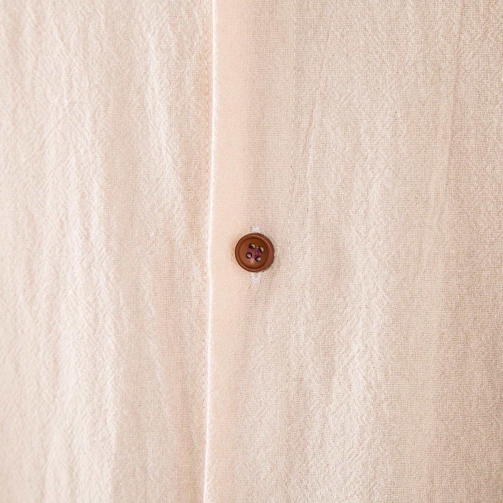 Dettaglio del tessuto in lino beige e del bottone del Completo Lido