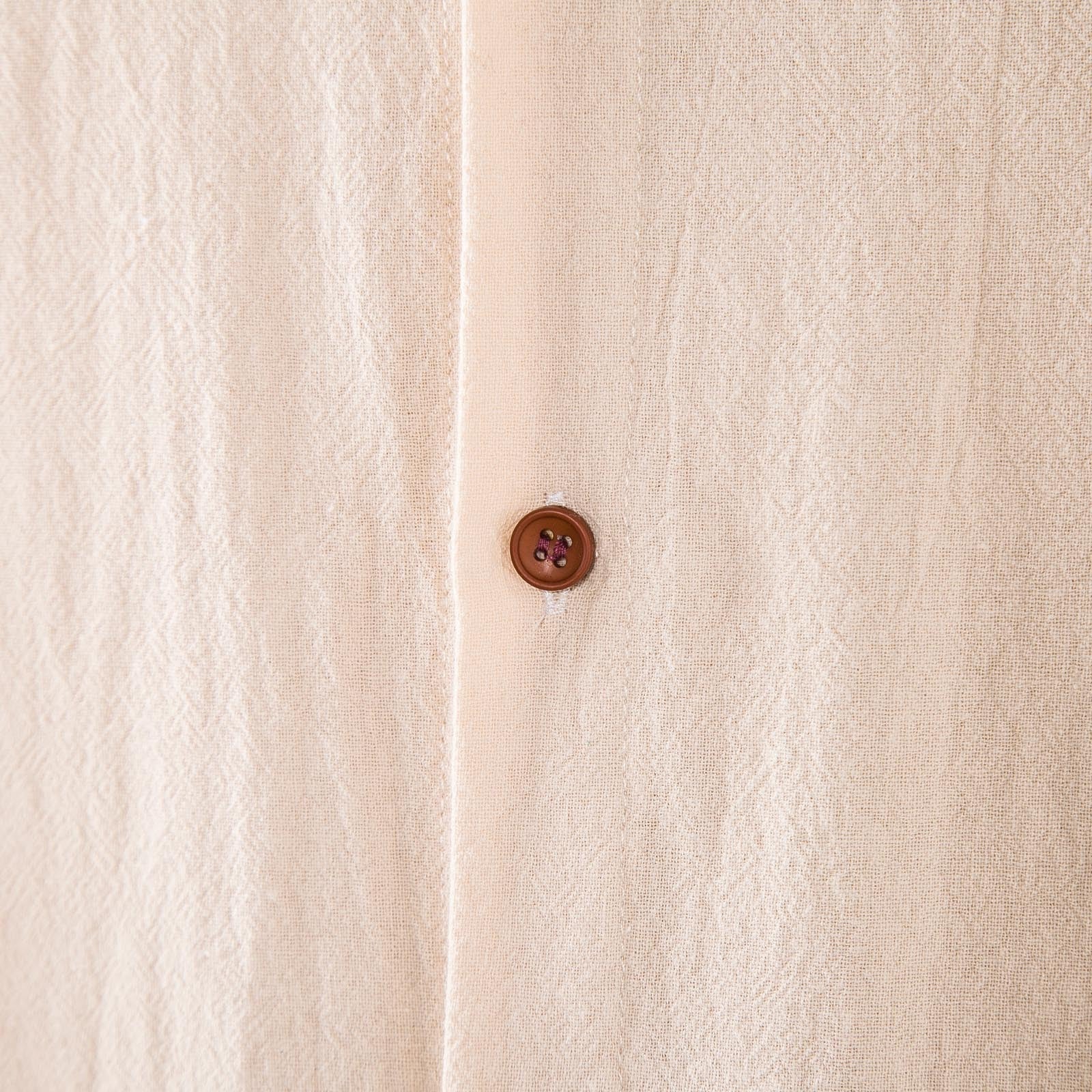 Dettaglio del tessuto in lino beige e del bottone del Completo Lido