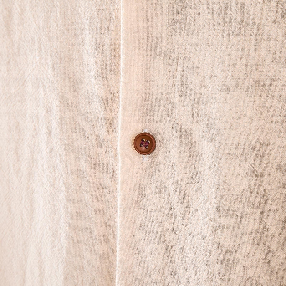 Dettaglio del tessuto in lino beige e del bottone del Completo Lido